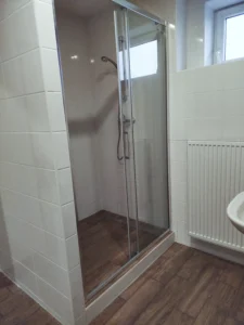 Instalatérské práce - Sprchové dveře v lesklém chromu. Výplň je z čirého skla bez dekoru.